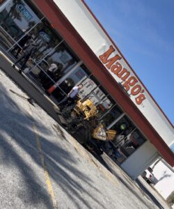Asphalt paver working at commercial storefront parking lot