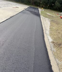 Freshly laid asphalt strip along parking lot edge